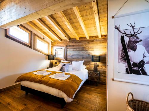 ein Schlafzimmer mit einem Bett und einem Bild eines Hirsches in der Unterkunft Chalet Les Gets, 6 pièces, 11 personnes - FR-1-598-66 in Les Gets