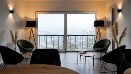 a room with a table and chairs and a large window at SI-View Doppelzimmer mit Stadtblick Zimmer 16 - Hotel in Siegen