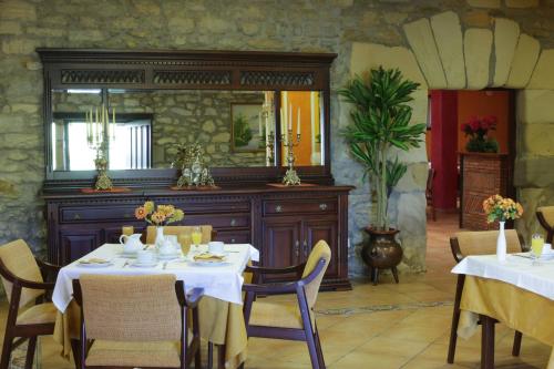 a dining room with two tables and a mirror at Hotel Casona Los Caballeros in Santillana del Mar