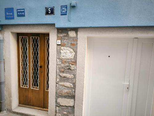 a blue building with a wooden door and a white door at Studio Apartment Ana in Zadar