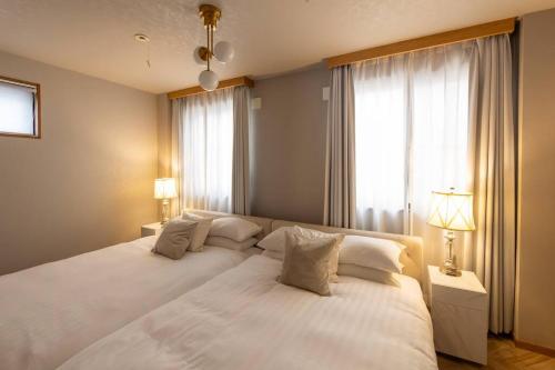 a large white bed in a room with a window at Tsutenkaku Royal House - Self Check-In Only in Osaka