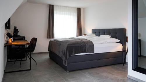 a bedroom with a bed and a desk and a window at SI-View Doppelzimmer mit Stadtblick Zimmer 16 - Hotel in Siegen
