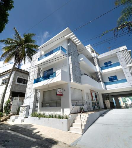 um edifício branco com uma palmeira em frente em Charming 2 bed 1 bath with Pool em Las Flores