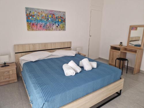 Un dormitorio con una cama azul con toallas. en Askeli Breeze, en Poros