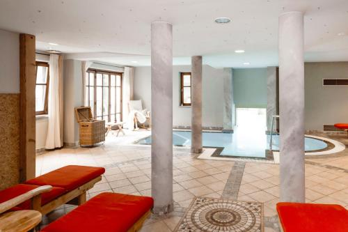 a large living room with a pool and columns at Boutiquehotel Hubertushof in Bad Ischl