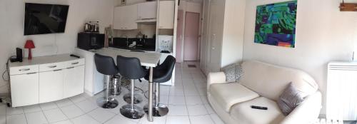 cocina y sala de estar con sofá y mesa en Residence calme, 5 minutes de la mer, gare, piscine, garage privé, en Vallauris