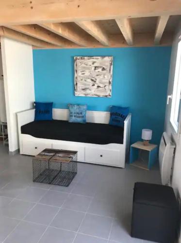 une chambre avec un grand lit avec un mur bleu dans l'établissement marine, à Foulerot