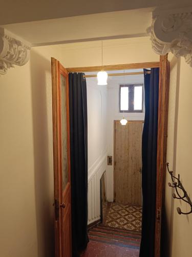 une porte ouverte menant à un couloir avec des rideaux bleus dans l'établissement Chambre d'hôte 1 pers - Maison avec terrasse et jardin près de la Friche de la Belle de Mai, à Marseille