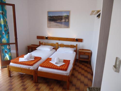 a bedroom with two beds with towels on them at PensionMargaritaKotroniSkiathos in Skiathos Town
