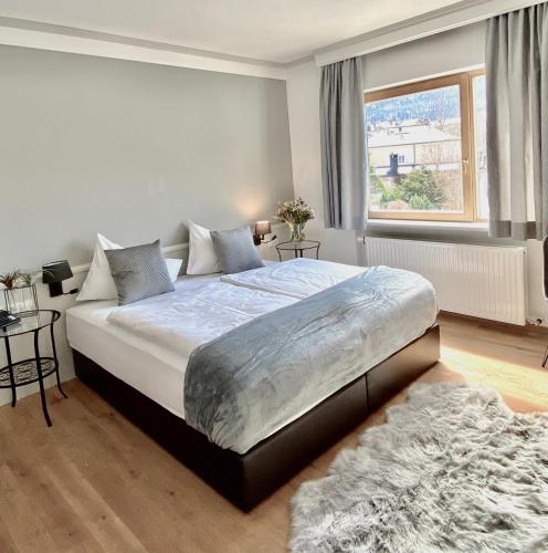 a bedroom with a large bed and a window at Boutiquehotel Hubertushof in Bad Ischl