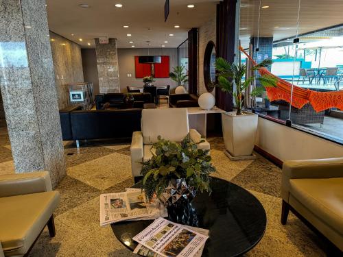a lobby with a table and chairs and a waiting room at Reymar Hotel Maceió in Maceió