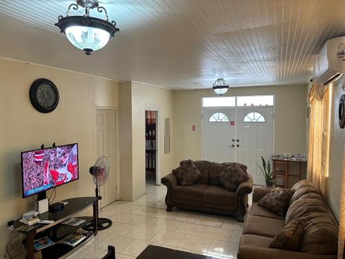 a living room with two couches and a flat screen tv at Modern Air Conditioned Home For Family & Adventure in Loubiere
