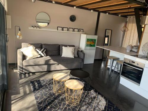 ein Wohnzimmer mit einem Sofa und 2 Tischen sowie eine Küche in der Unterkunft Chalet indépendant au calme à 10 minutes d'Annecy in Villaz