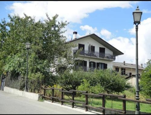 una casa blanca con una valla delante en Lo noú, en Aosta