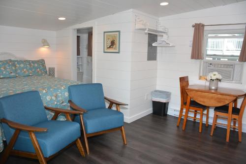 um quarto com uma cama, cadeiras e uma mesa em Echo Motel em Old Orchard Beach