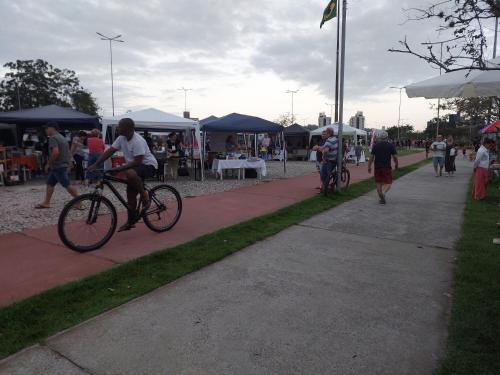 a man riding a bike on a sidewalk at Excelente Quarto prox centro Criciuma in Criciúma