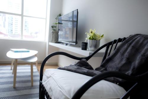 a living room with a chair and a table at The Town Apartments in Melbourne