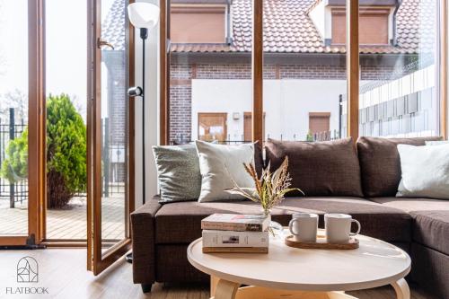 a living room with a couch and a table at Flatbook Apartamenty - Mikoszewo Dom Amber Cottage in Nickelswalde