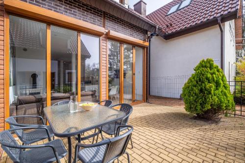 a patio with a table and chairs on it at Flatbook Apartamenty - Mikoszewo Dom Amber Cottage in Mikoszewo