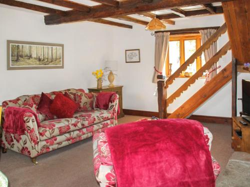 a living room with a couch and a staircase at Millstone Cottage - Uk46676 in Highley