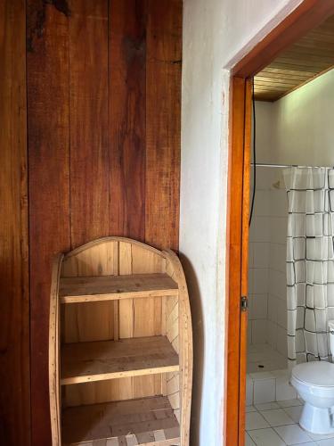 a bathroom with a wooden shelf next to a toilet at Chamisal Jungle Hotel in Lima