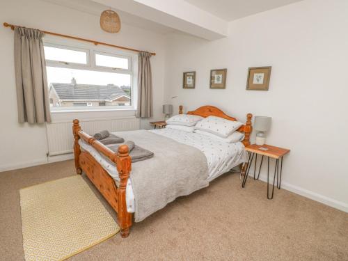 a bedroom with a large bed and a window at Awelfryn in Rhosneigr