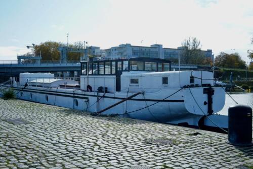 um barco está ancorado numa doca na água em Grande suite avec terrasse sur le fleuve em Nantes