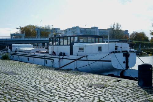 un bateau est amarré à un quai dans l'eau dans l'établissement Grande suite avec terrasse sur le fleuve, à Nantes