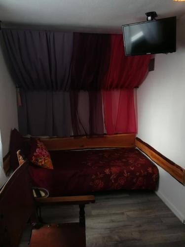 a small room with a bed and a curtain at Gästehaus Fuchsröhre in Welcherath