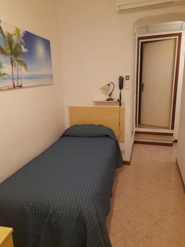 a bedroom with a bed and a phone on the wall at Hotel Anselmi in Marciana Marina