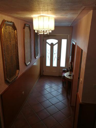 a hallway with a door and a chandelier at Gästehaus Fuchsröhre in Welcherath