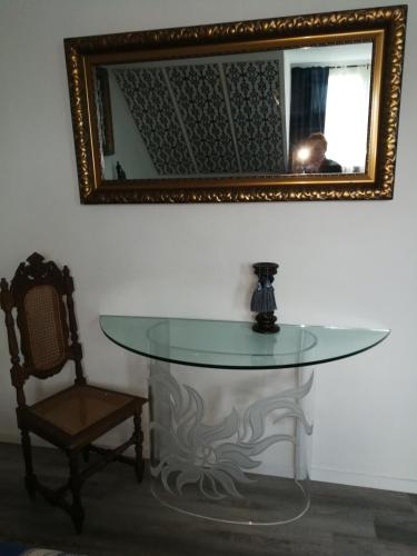 a glass table with a mirror and a chair at Gästehaus Fuchsröhre in Welcherath