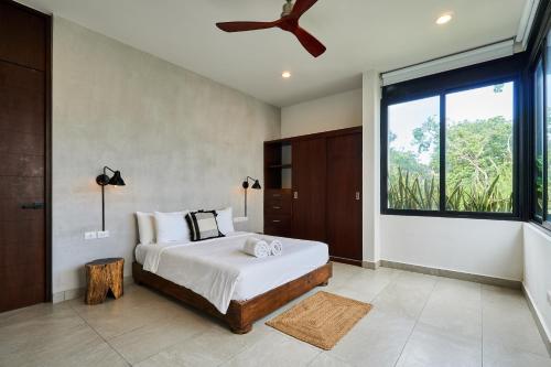a bedroom with a bed and a large window at Casa Aventura Secluded Oasis 24h Security Near Sandy Beaches in Tulum