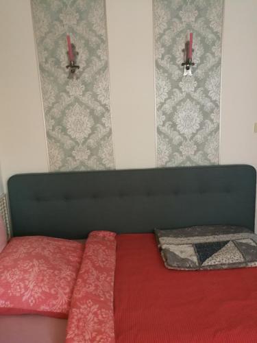 a bedroom with a bed with a red comforter at Gästehaus Fuchsröhre in Welcherath
