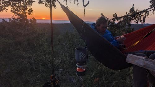 a man lying in a hammock with a drink at Tree Climbing at Silver Falls in Sublimity