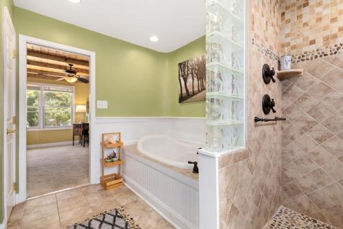 a bathroom with a tub and a shower with green walls at Edgewatermayo Getaway! in Edgewater