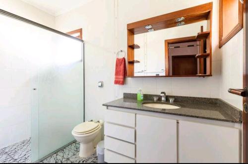 La salle de bains est pourvue de toilettes, d'un lavabo et d'une douche. dans l'établissement Casa na Granja Viana - Cotia, à Cotia