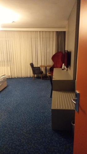 Acar Suite Hotel في إسطنبول: غرفة في الفندق مع أريكة وكرسي