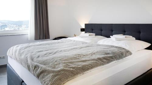 two beds in a bedroom with a large window at SI-View Doppelzimmer mit Stadtblick Zimmer 20 - Hotel in Siegen