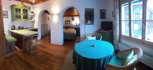 a living room with a blue table and a kitchen at Pension Kirchleitn in Turnau