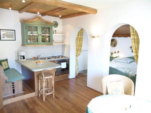 a room with a kitchen and a bedroom with a bed at Pension Kirchleitn in Turnau