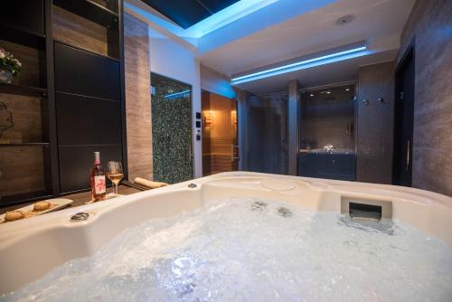 a large bath tub in a bathroom with a window at Hotel Sun Loznica in Loznica