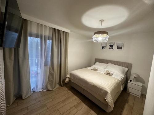 ein kleines Schlafzimmer mit einem Bett und einem Fenster in der Unterkunft Apartamenty Biała Grań in Zakopane