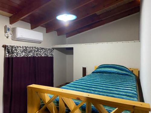 ein Schlafzimmer mit einem Bett mit einer blau gestreiften Decke in der Unterkunft Hostel joel 2 in Moreno
