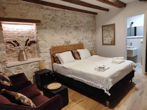 ロヴィニにあるCasa di Luna Rovignoの石壁のベッドルーム1室(大型ベッド1台付)