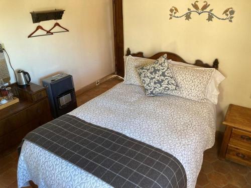 a bedroom with a large bed and a television at Hotel Amor y Paz in Real de Catorce