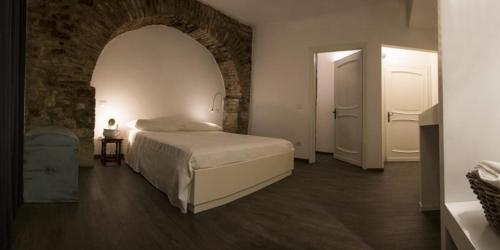 a bedroom with a bed and a brick wall at Residenza La Corte Assisi in Assisi