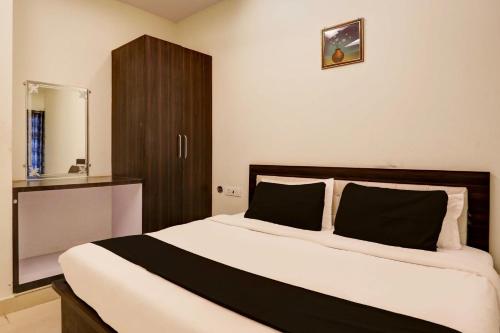 a bedroom with a large white bed with black pillows at OYO Flagship Hotel Sky Inn in Chinhat