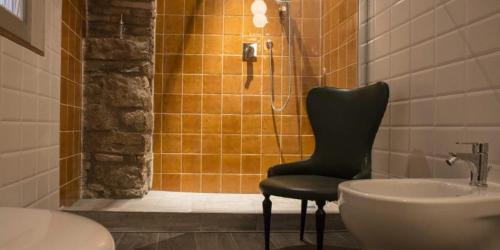 prysznic z krzesłem obok umywalki w obiekcie Residenza La Corte Assisi w Asyżu