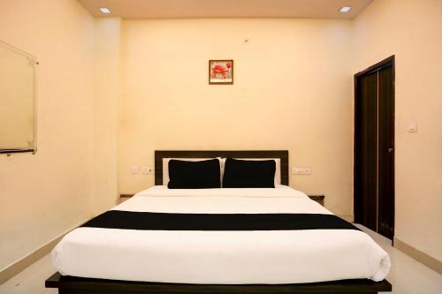 sypialnia z dużym białym łóżkiem z czarnymi poduszkami w obiekcie OYO Flagship Hotel Sky Inn w mieście Chinhat